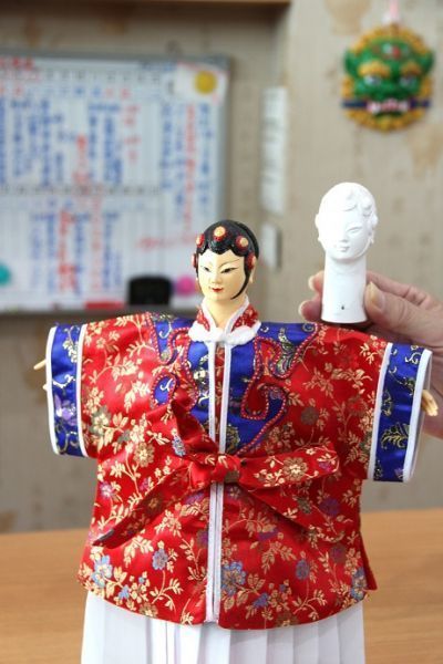 在師傅教導下為戲偶彩繪五官、穿上刺繡衣裳